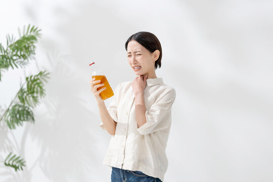 ペットボトルのお茶を飲む女性