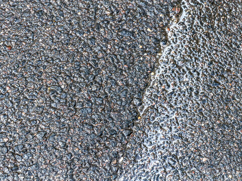 dark wet asphalt texture. rainy road surface. textured background. closeup view.