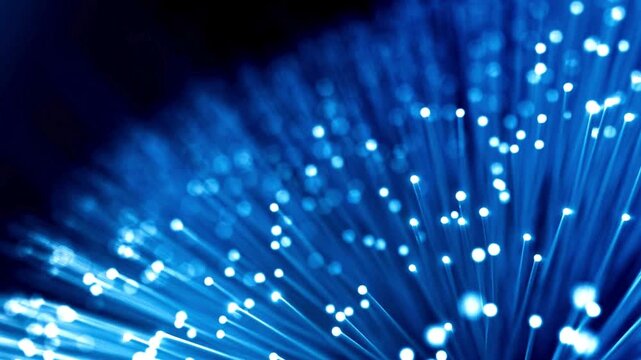 Abstract blue fiber optic cables with glowing light pulses in motion creating dynamic digital communication network background for high speed data footage.