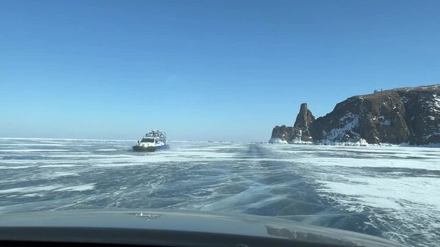Video from inside a car, filmed during a drive along the ice road to the northern tip of Olkhon Island, the famous Cape Khoboy, popular tourist attraction. Winter ice travel 