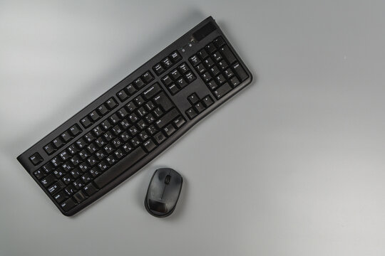 Modern keyboard and mouse on a gray office desk