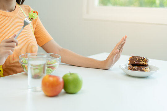 Beauty slim female body confuse chocolate cake. Woman in restaurant achieves weight loss goal for healthy life, crazy about thinness, thin waist, nutritionist. Diet, body shape.