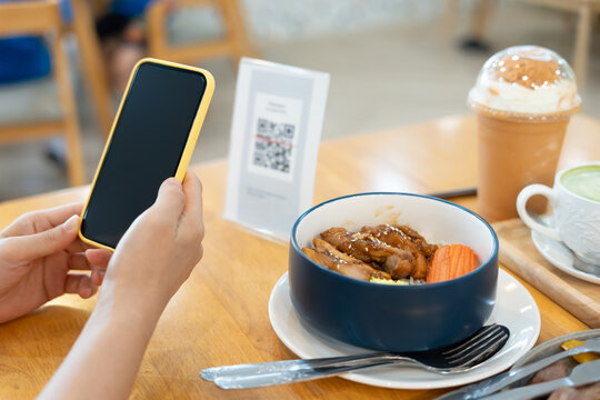 Woman use smartphone to scan QR code to pay in cafe restaurant with a digital payment without cash. Choose menu and order accumulate discount. E wallet, technology, pay online, credit card, bank app.