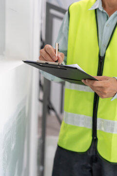 inspector or engineer is inspecting construction and quality assurance new house using a checklist. Engineers or architects or contactor work to build the house before handing it over to the homeowner