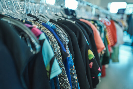 Sequined and textured clothing on a rack at a thrift store
