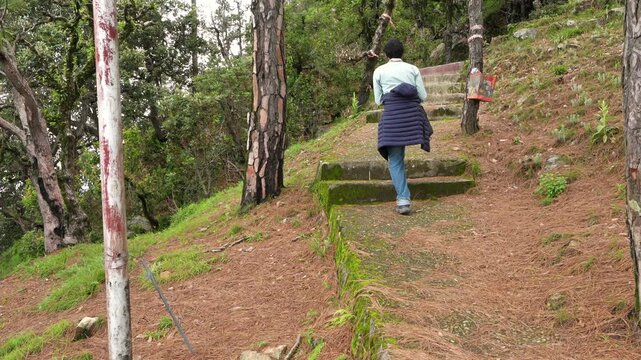 Unrecognizable Traveler Climbing Concrete Stairs Covered In Pine Needles In Forest