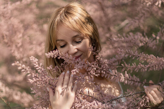 Woman nature pink blooms enjoying spring tamarix plant