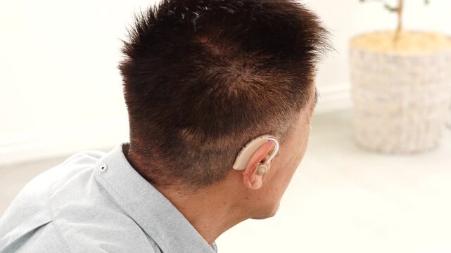 補聴器を付けたシニア男性　リビング