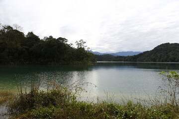 Calm lake water surrounded by lush mountains. © eric1207cvb