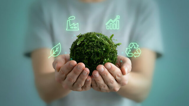 Person holding green moss sphere with eco icons for corporate ESG sustainability and industrial decarbonization