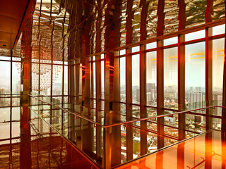 Fototapeta premium Spacious glass atrium with reflections on polished floor and panoramic windows. Empty lobby features