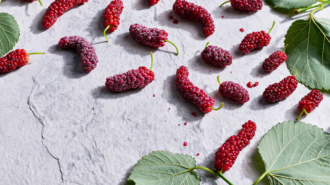 Fresh ripe red mulberries with green leaves on light textured background, isolated on transparent background, highlighting sweet and healthy summer berries.