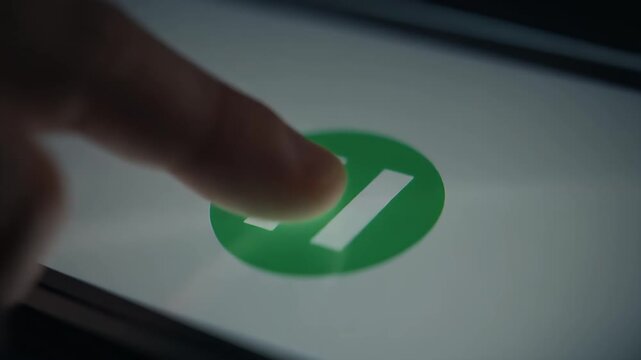 A finger pressing a pause button icon on a digital screen.