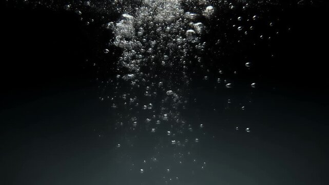 Abstract underwater view of rising bubbles against a dark background.