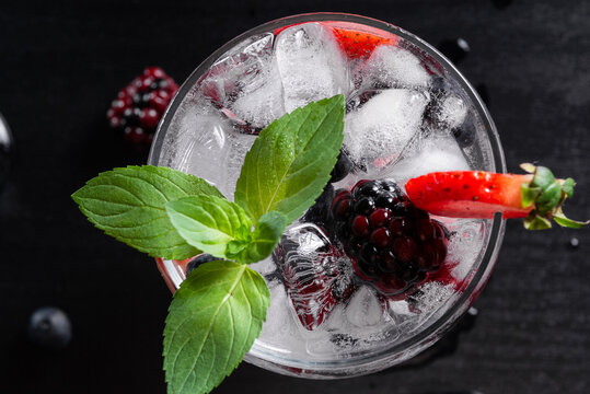 Top Down Berry Mocktail With Mint and Ice on Dark Wood