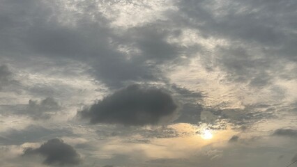 Obraz premium Dramatic Cloudy Sky with Golden Sunlight Shining Through Dark Clouds