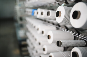 Obraz na płótnie Canvas White yarn spools moving on textile production machine