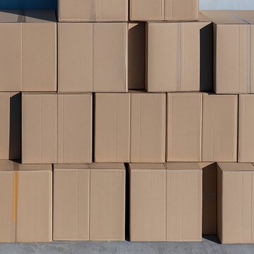 Stacked kraft cardboard boxes create a textured repeating pattern with matte surfaces and hard shadows for logistics and cargo supply backgrounds