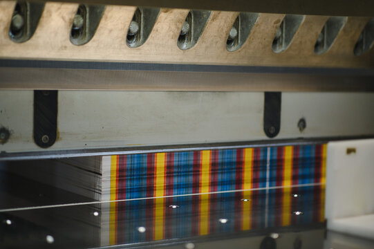 Stacking paper sheets cut by guillotine in printing house