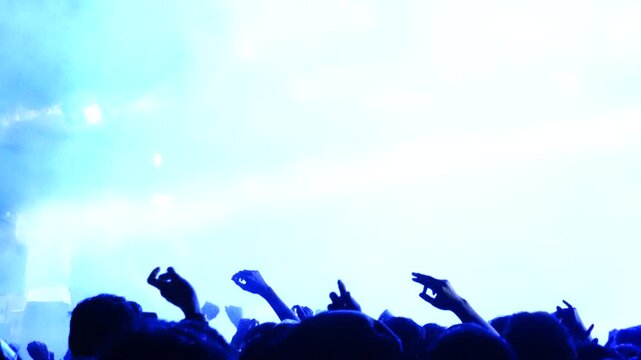 Silhouetted Concert Audience Under Bright Blue Stage Lights