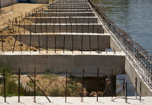 Building process city levee. Exposed foundation rebar grid at site, standing formwork and concrete footings