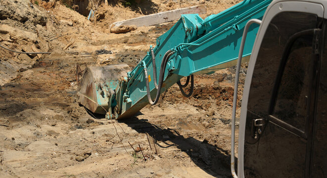 Building process city levee. Excavator dredging pond bank