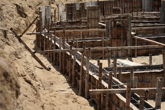 Building process city levee. Exposed foundation rebar grid at site, standing formwork and concrete footings