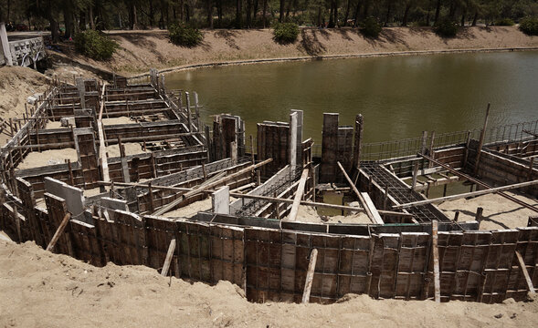 Building process city levee. Exposed foundation rebar grid at site, standing formwork and concrete footings
