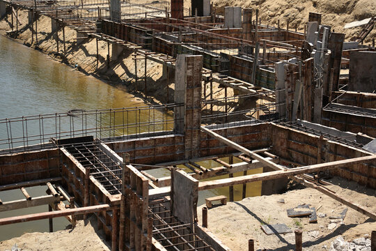 Building process city levee. Exposed foundation rebar grid at site, standing formwork and concrete footings
