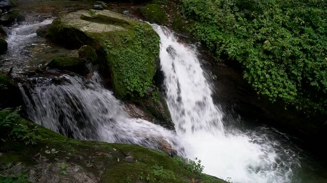 Beautiful waterfall on the way trekking to Annapurna base camp ABC - green natural scene at annapurna national park Nepal - footage 4K