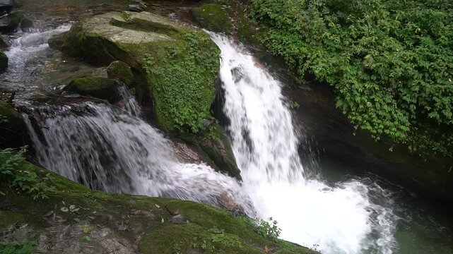 Beautiful waterfall on the way trekking to Annapurna base camp ABC - green natural scene at annapurna national park Nepal - footage 4K