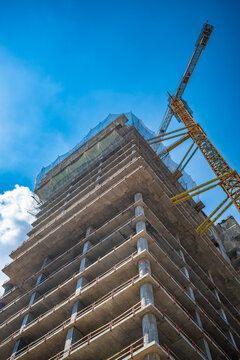 Low angle view of modern building under construction against blue sky