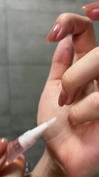 Woman's hands applying nourishing cuticle oil pen for nail care, close up of manicure and skincare routine, beauty concept promoting healthy fingers and nailbeds