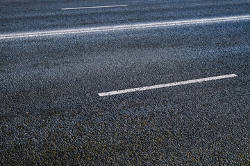 Fototapeta premium A section of asphalt road with visible road markings