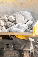 Yellow dumper filled with concrete rubble The Concept of demolition and heavy labor © VicVaz