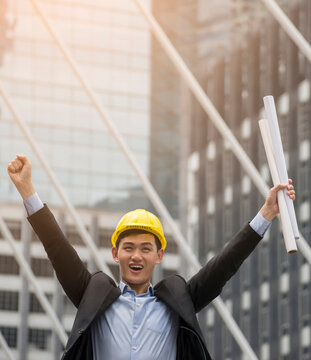 Professional Construction engineer Manager wear safety yellow helmet holding Blueprint feeling success after complete building project with better structures. Construction Engineering concept-vertical