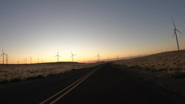 4K action camera driver's point of view of a wind farm near Arlington, Columbia River Gorge, Oregon, USA at morning light. Rotating wind turbines producing clean renewable electricity in strong winds