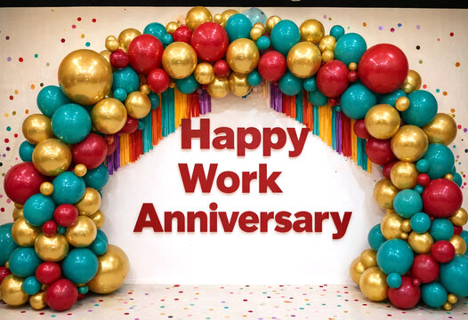 Colorful balloon arch decoration with golden red and teal balloons for work anniversary celebration event
