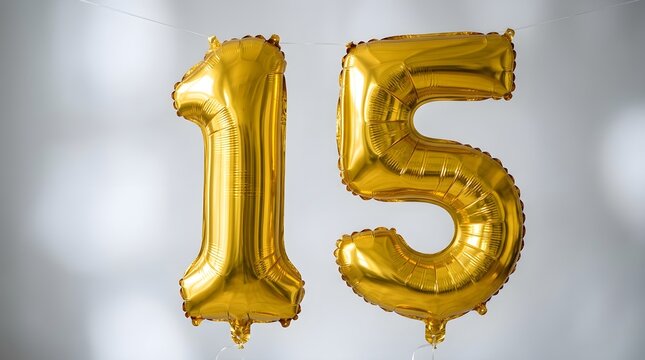Shiny golden foil number fifteen balloons float beautifully against a soft blurred white backdrop symbolizing a special milestone birthday or anniversary event