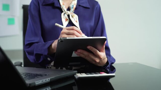 Female business clicking internet search page on computer and tablet touch screen in office.