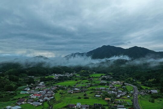 Aerial drone photo of misty mountain valley with farmland at sunrise in Mie, Japan