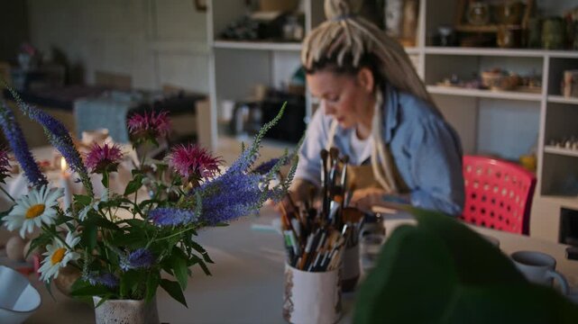 Wild flower bouquet against female artisan working on project
