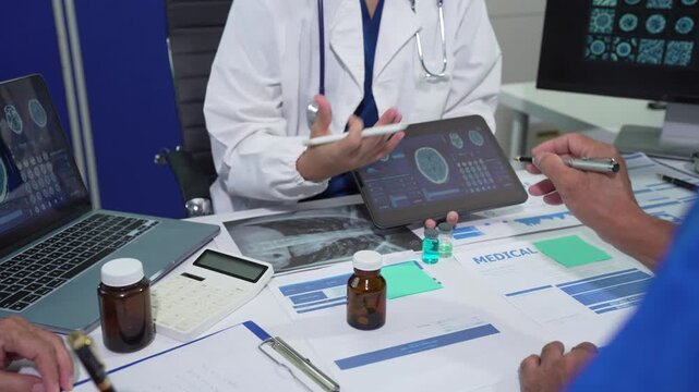 Medical team working with a tablet and Laptop computer search for medical information at the hospital office.