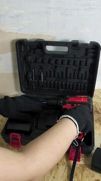 Mechanic putting cordless screwdriver and tools into case after work, workshop organization, repair and maintenance concept.