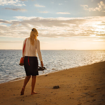 Jeune femme blonde marchant sur la plage le soir. Vacances c&eacute;libataire. Touriste sur une plage &agrave; La R&eacute;union. Belle femme en vacances