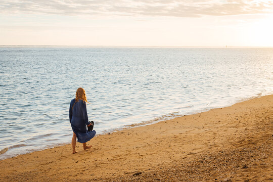 Jeune femme rousse marchant sur la plage le soir. Vacances c&eacute;libataire. Touriste sur une plage &agrave; La R&eacute;union. Belle femme en vacances