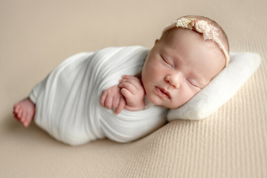 Peaceful infant resting during a studio session in a cozy beige setting