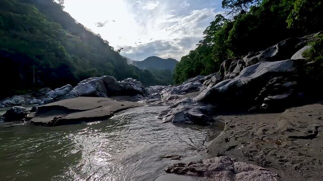 Wide Rocky Riverbed in Tropical Ecuador Valley with Smooth Boulders, Forested Hills, Freshwater Stream and Scenic Jungle Travel Landscape