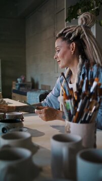 Lady ceramic artist records mug measurements for webshop listing