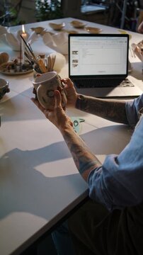 Potter inspects ceramic mug for damage before final sale